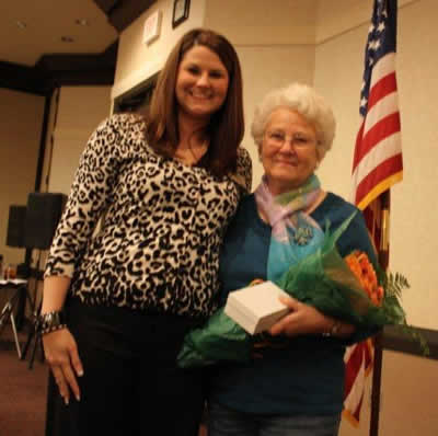 Stephanie McCurdy presenting roses and a gift to retiring historian, Viola Beatty.