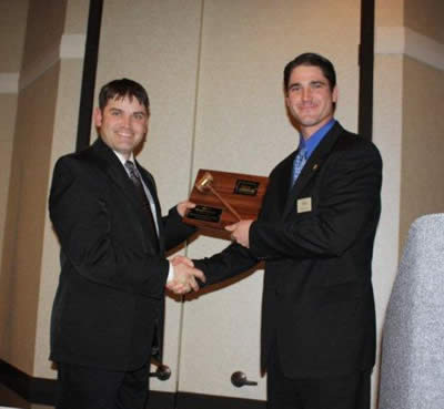 Charly Cummings, the Bid Call Champion for 2009 is presented his plaque by Byron Bina.