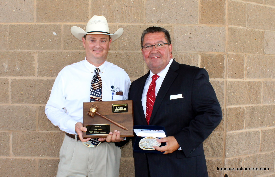 Lance Fullerton, 2014 Champion, presents Lenny Mullin with the 2015 Kansas Auctioneer Championship belt buckle and plaque.